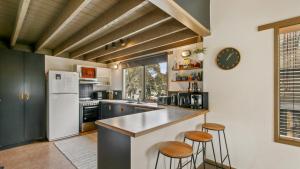 a kitchen with a white refrigerator and two bar stools at Aaragon in Dinner Plain