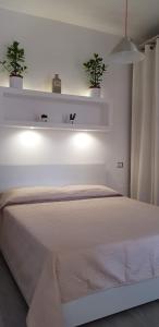 a bedroom with a white bed with two potted plants at Loft 51 Castel Gandolfo in Castel Gandolfo