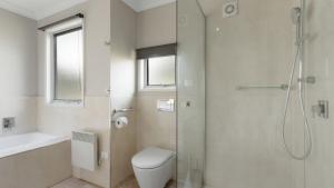 a bathroom with a shower and a toilet and a sink at Hideaway in Dinner Plain +8 photos