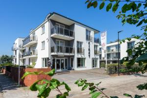 a white building with balconies on a street at Pensjonat Pirat in Jastrzębia Góra