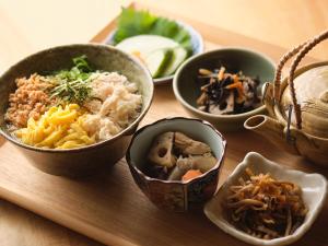 a group of bowls of food on a wooden table at HOTEL SUI AKASAKA by ABEST in Tokyo