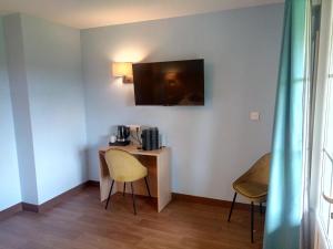 TV a/nebo společenská místnost v ubytování Brit Hotel Confort - La Tour Blanche