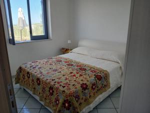 una camera da letto con un letto con una coperta a fiori di Fin Fiori a Menfi
