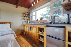 Una cocina con fregadero y una cama en una habitación. en Columbine Cabin at Highland Meadows, en Hot Springs