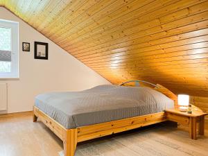 ボルテンハーゲンにあるUrlauberdorf Haus 20aの木製の天井の客室のベッド1台分です。