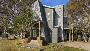 a large house with a gray house at Numbawan in Dinner Plain
