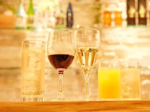 three glasses of wine and some drinks on a table at HOTEL SUI AKASAKA by ABEST in Tokyo