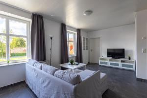 ein Wohnzimmer mit Couch und Fernseher in der Unterkunft Ferienhaus Natura Ideal für Urlaub & Business, Küche, WLAN, Parkplatz in Rhauderfehn
