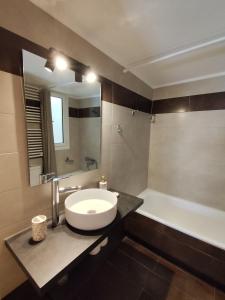 a bathroom with a white sink and a bath tub at Xasteria apartment Ξαστεριά in Poros