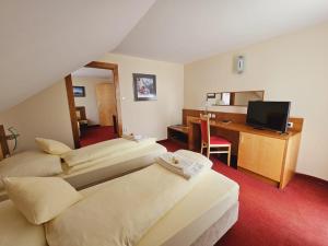 a hotel room with two beds and a desk at Penzión KOVOX in Staškov