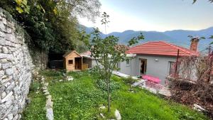 a small house in a field next to a building at Footpath House / Ολόκληρο σπίτι στο Μεγάλο Χωριό in Méga Khoríon