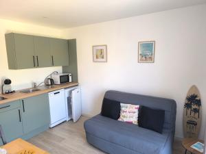 a living room with a blue couch in a kitchen at Plouharnel-Carnac-Quiberon bord de mer in Plouharnel
