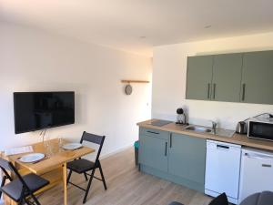 a small kitchen with a table and a table and chairs at Plouharnel-Carnac-Quiberon bord de mer in Plouharnel