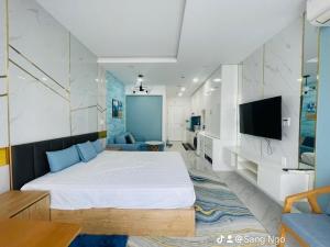 a bedroom with a large bed and a tv at Comfortable Family Apartment at Sealinks Mui Ne in Ấp Ngọc Hải