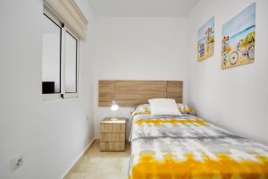 a small bedroom with a bed and a window at Marysol in Caleta De Fuste +20 photos