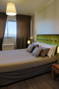 a bedroom with a large bed with a green headboard at Hôtel Albion in Ajaccio