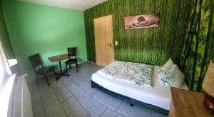 a bedroom with green walls and a bed and a table at Bauernhof Privatzimmer Free WiFi Gemeinschaftsbad in Hausbreitenbach