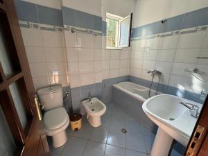 e bagno con servizi igienici, lavandino e vasca. di Guesthouse Kleanth a Sarandë