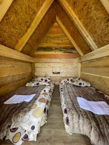 a room with two beds in a wooden attic at Eko Kamp Garcevic in Plav