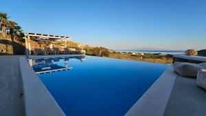 a swimming pool with blue water on a house at Mykonos4Islands Seaside Apartments in Kalo Livadi