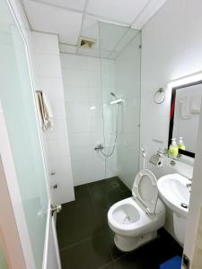 a white bathroom with a toilet and a sink at Khách sạn Nam Môn in Can Tho