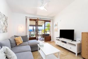 a living room with a couch and a tv at Casita Seafront Oasis del Sur in San Miguel de Abona