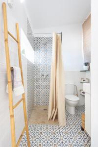 a bathroom with a shower curtain and a toilet at Casita Seafront Oasis del Sur in San Miguel de Abona