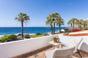 a balcony with a table and chairs and the ocean at Casita Seafront Oasis del Sur in San Miguel de Abona