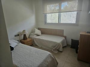 サガロにあるApartamento en s'agaroのベッド2台と窓のある寝室