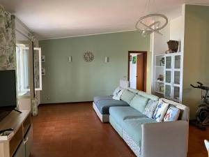 a living room with a blue couch and a television at Villa Spaziosa con vista mare in Capitello