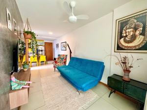 a living room with a blue couch and a tv at Lar Expresso 2222 in Salvador