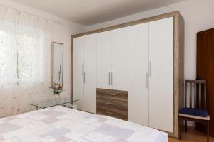 a bedroom with a large white closet and a bed at Apartman Angelina in Supetar