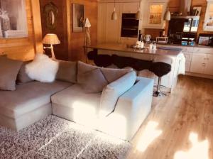 un soggiorno con un divano bianco e una cucina di Cozy Scenic Family Chalet Gstaad Glacier 3000 a Gsteig