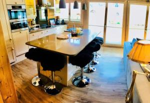 una cucina con tavolo e sgabelli di Cozy Scenic Family Chalet Gstaad Glacier 3000 a Gsteig Altre 12 foto
