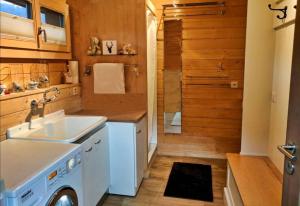 una cucina con lavello e lavatrice di Cozy Scenic Family Chalet Gstaad Glacier 3000 a Gsteig