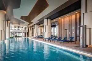 ホーチミン・シティにあるZeus Living - Glorious Palace & Concept in Q2 Thao Dienの大型スイミングプール(青い椅子付)