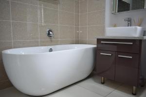 bagno con vasca bianca e lavandino di Candymore luxury apartment a Midrand Altre 6 foto