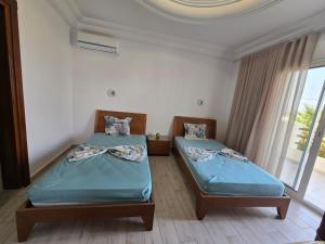 deux lits jumeaux dans une chambre avec fenêtre dans l'établissement Villa Elaa, à Temlale