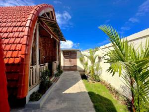 a house with a red roof and a pathway at Nature Stay Uluwatu in Uluwatu