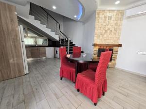 une salle à manger avec une table et des chaises rouges dans l'établissement Villa Elaa, à Temlale
