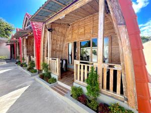 a wooden building with a porch with plants on it at Nature Stay Uluwatu in Uluwatu