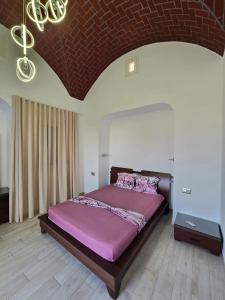 - une chambre avec un grand lit et une couette violette dans l'établissement Villa Elaa, à Temlale