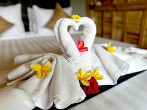 two towels in the shape of a swan on a bed at Nature Stay Uluwatu in Uluwatu +19 photos