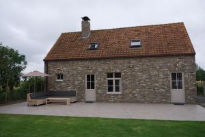 a brick building with a couch and a table at Hof Ter Meulen in De Haan