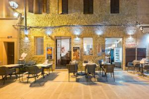 a restaurant with tables and chairs in front of a stone building at Hotel Can Simo in Alcudia