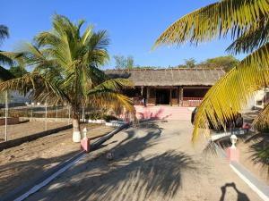 a building with two palm trees in front of it at Toscana Villa in Mahajanga
