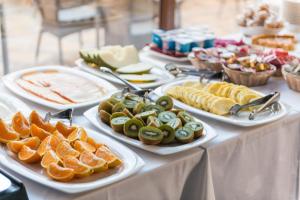 a table with plates of fruit and vegetables on it at Hotel Can Simo in Alcudia