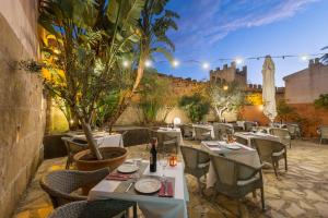 a restaurant with tables and chairs with a castle in the background at Hotel Can Simo in Alcudia
