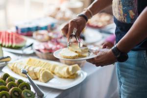 a person holding a plate of food on a table at Hotel Can Simo in Alcudia