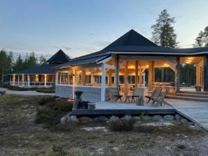 a large house with a porch and a deck at HUNURIJÄRVI RESORT***** in Härmä